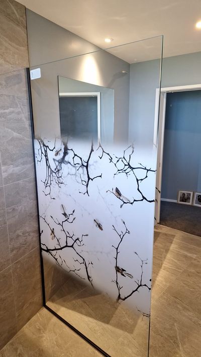 Printed frameless shower screen with a branch design, second angle